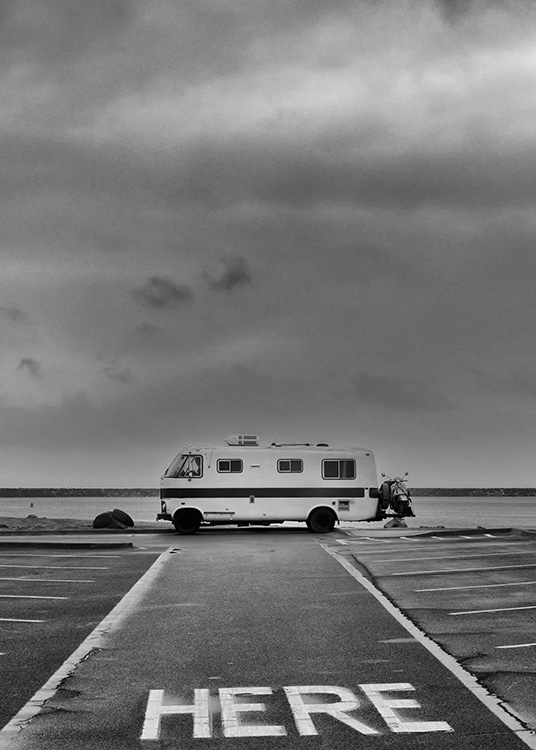  - Schwarzweißes Retroposter eines alten Wohnmobils auf einem leeren Parkplatz am Meer.