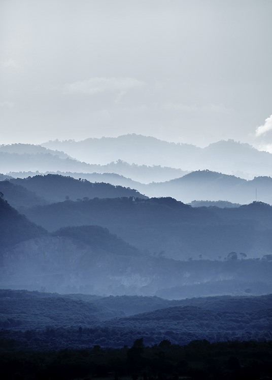  - Atemberaubende Landschaftsaufnahme mit mit Nebel verhangenen Bergen in verschiedenen Blautönen.