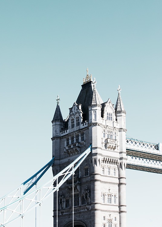  - Nahaufnahme eines Turms der Tower Bridge vor hellblauem Himmel in London.