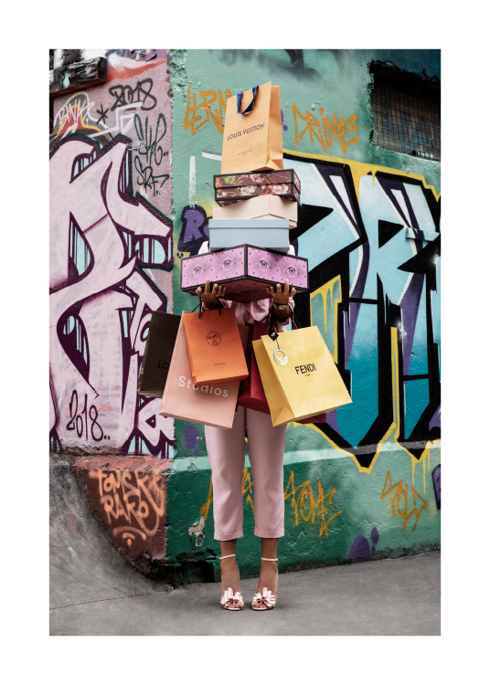  – Fotografie einer Frau, die Schuhkartons und Taschen trägt, im Hintergrund eine Graffiti-Wand