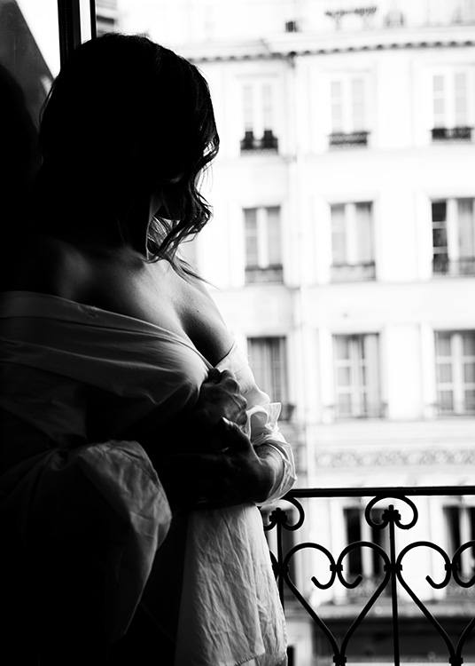– Schwarz–Weiß–Foto einer am Fenster stehenden Frau