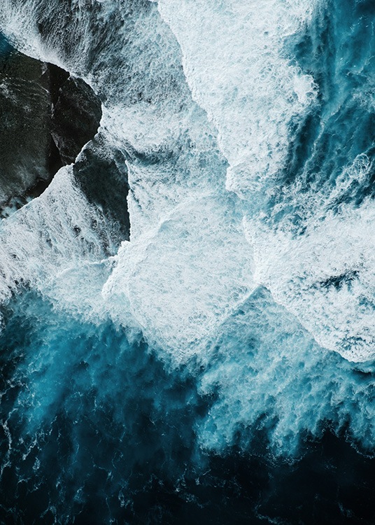 –Meereswellen treffen auf einen Felsen, der von oben fotografiert wurde.