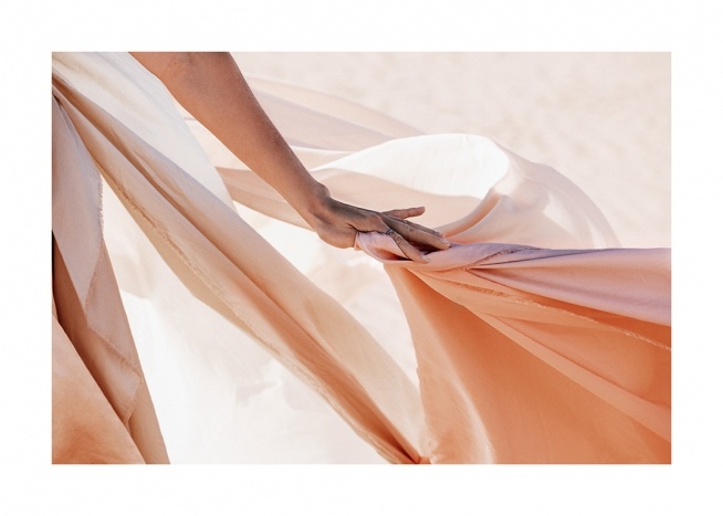  – Fotografie: Zarter pfirsichfarbener Stoff, der von einer Frauenhand gehalten wird