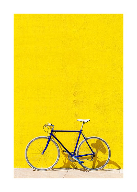 Blaues Fahrrad, das vor einer leuchtend gelben Wand steht