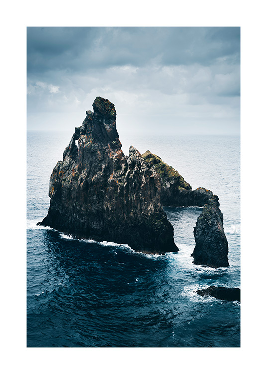  - Fotografie eines blauen Meers mit großen Felsformationen in der Mitte
