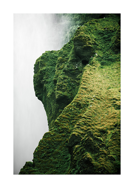  - Fotografie, die den Wasserfall Skógafoss an einem grünen Felsen zeigt