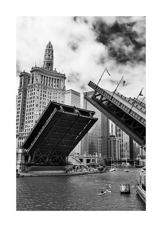  - Schwarz-weiß-Fotografie von der sich öffnenden Chicago Bridge, im Hintergrund Boote auf dem Fluss und Gebäude