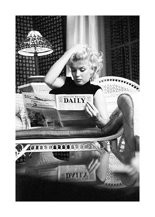  – Schwarz-weiß-Fotografie der Ikone Marilyn Monroe, die auf dem Sofa Zeitung liest