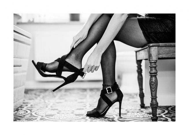  – Schwarzweißfoto einer Frau, die ein Paar High Heels anzieht