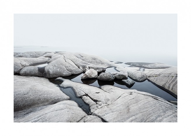  – Fotografie einer Küstenlinie mit glatten Felsen und Wasser dazwischen