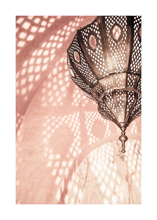  - Fotografie eines rosa Zimmers mit einer Metalllampe, die ein Muster an der Wand reflektiert