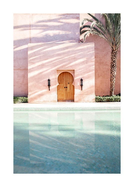  - Fotografie einer Palme neben einem rosa Gebäude mit einem Pool davor