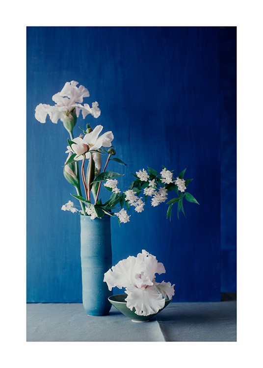  – Fotografie einer blauen Vase mit weißen Blumen, dahinter eine dunkelblaue Wand