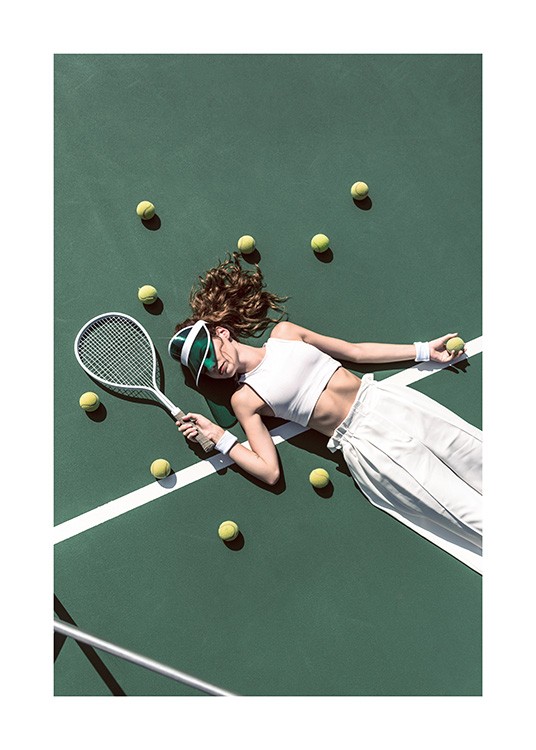  – Fotografie mit einem Mädchen in weißen Hosen und einem weißen Oberteil, das umgeben von Tennisbällen auf einem Tennisplatz liegt