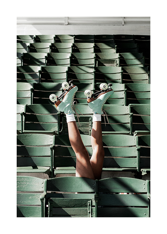  – Fotografie von Beinen in Rollschuhen, die zwischen grünen Sitzen in einem Stadium nach oben ragen