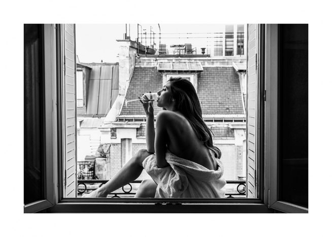  – Schwarz-Weiß-Fotografie einer Frau, die im offenen Fenster sitzend an einem Glas Wein nippt