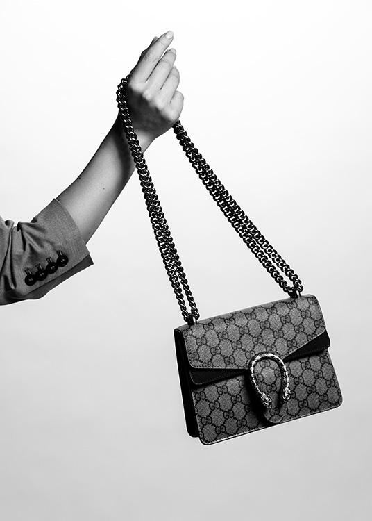  – Schwarz-Weiß-Fotografie einer Gucci-Handtasche, die von der Hand einer Frau gehalten wird