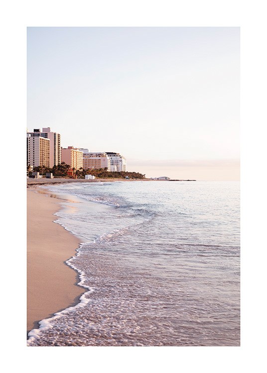  – Fotografie von Wellen, die auf den Strand von Miami auflaufen, im Hintergrund Gebäude