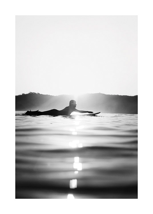  – Schwarz-weiß-Fotografie eines Surfers, der auf einem Surfbrett im Wasser liegt