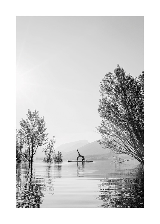  – Schwarz-weiß-Fotografie einer Frau in einer Yoga-Stellung auf einem Surfbrett mitten auf einem See