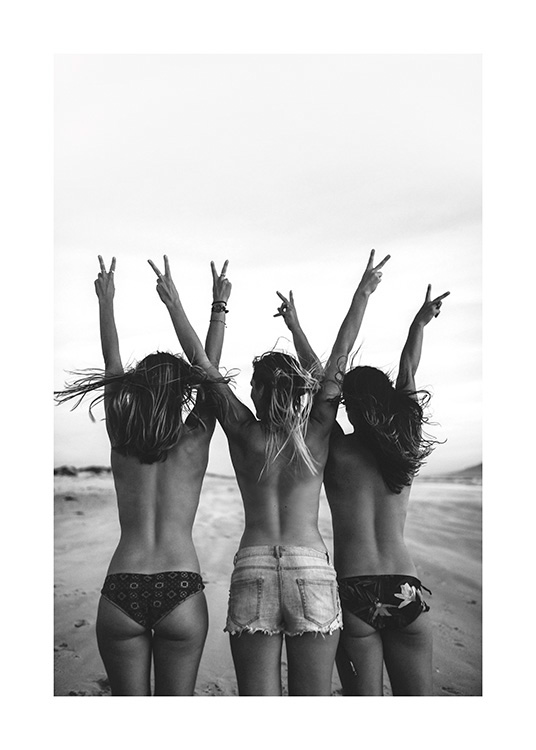  – Schwarz-weiß-Fotografie von drei Frauen in Shorts und Bikinihose, die mit hochgestreckten Armen das V-Zeichen machen