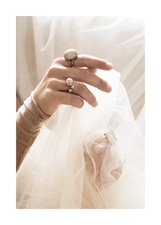  – Fotografie einer Frau mit Ringen an den Fingern, die weißen Tüllstoff in ihren Händen hält