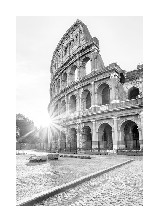  – Schwarz-weiß-Fotografie des Kolosseums in Rom mit Sonnenstrahlen im Hintergrund