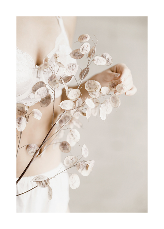  – Frau, die getrocknete, beige Blumen in ihren Händen hält