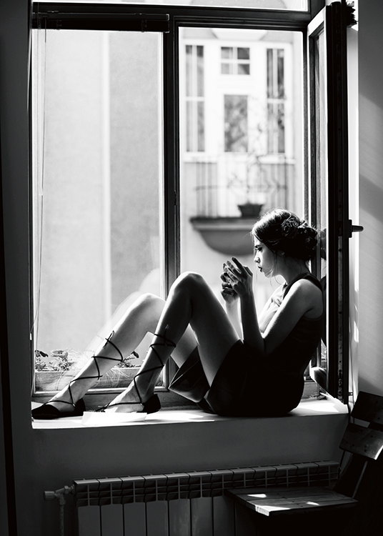  – Schwarz-weiß-Fotografie einer Frau, die in einem offenen Fenster sitzt und eine Tasse hält