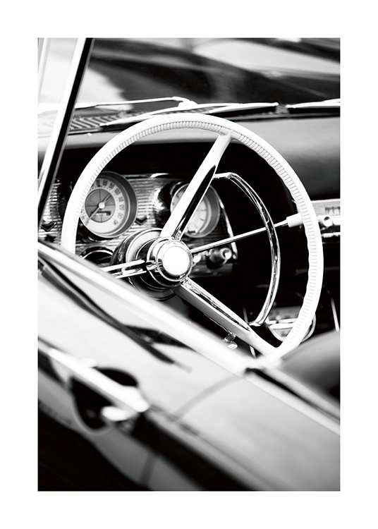  – Schwarz-weiß-Fotografie, die das Lenkrad und das Armaturenbrett eines Oldtimer-Cabriolets zeigt