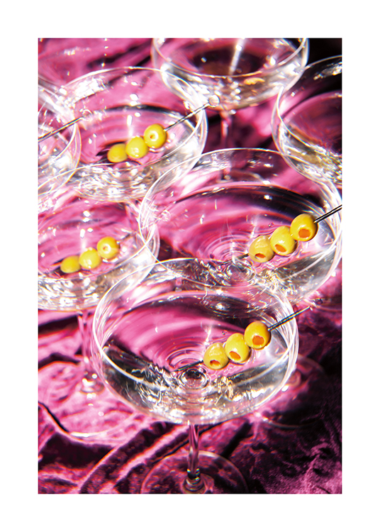 – Fotografie mit mehreren Martini-Cocktails vor rosa Hintergrund