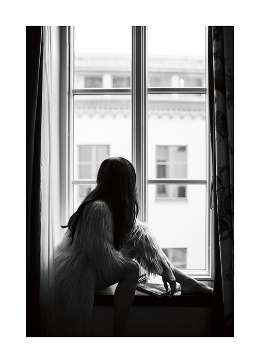  – Schwarz-weiß-Fotografie einer dunkelhaarigen Frau, die in einer Kunstpelzjacke auf einer Fensterbank sitzt