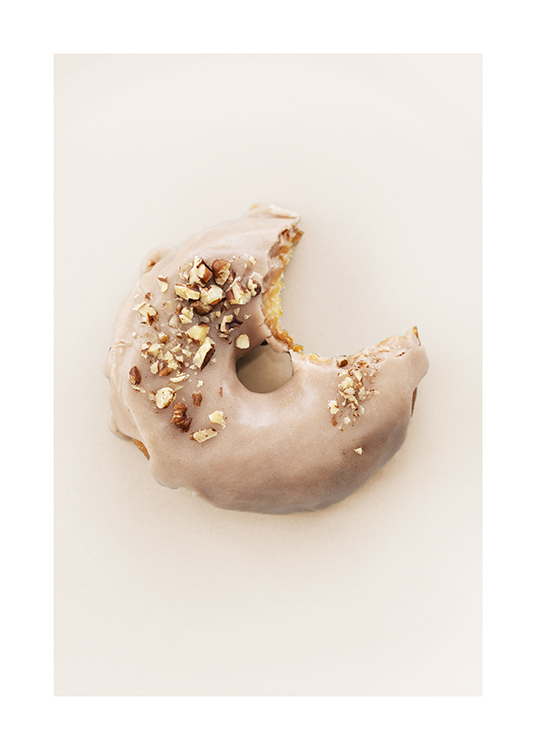  – Fotografie eines Donuts mit beiger Glasur und gehackten Nüssen