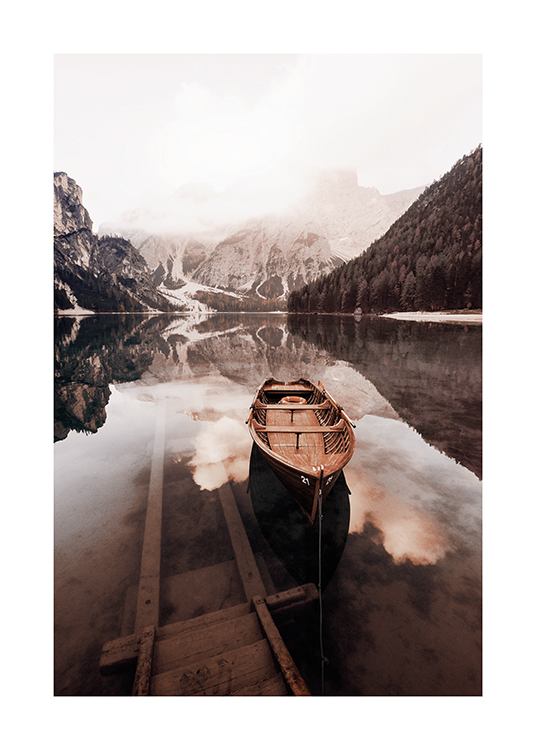  – Fotografie eines kleinen Holzbootes auf einem stillen See mit schneebedeckten Bergen im Hintergrund