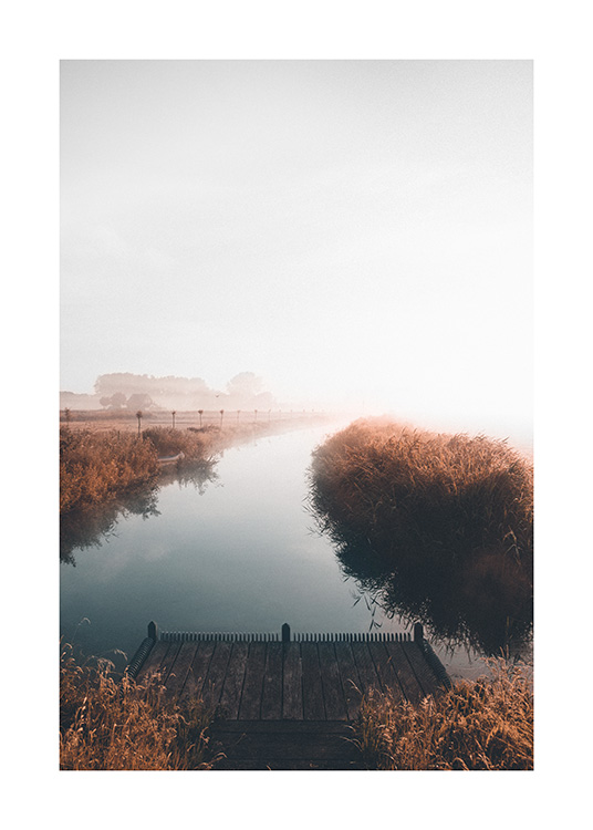  – Fotografie eines ruhigen Sees mit nebliger Landschaft im Hintergrund und einem kleinen Steg im Vordergrund
