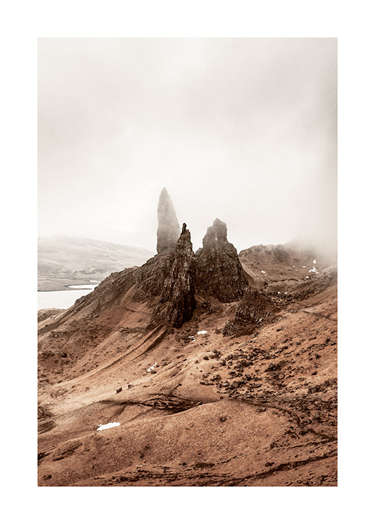  – Fotografie einer Landschaft im Nebel mit hohen Felsen in der Bildmitte