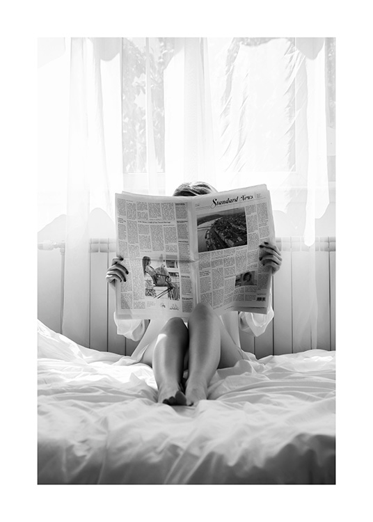  – Schwarz-Weiß-Fotografie einer Frau, die im Bett Zeitung liest