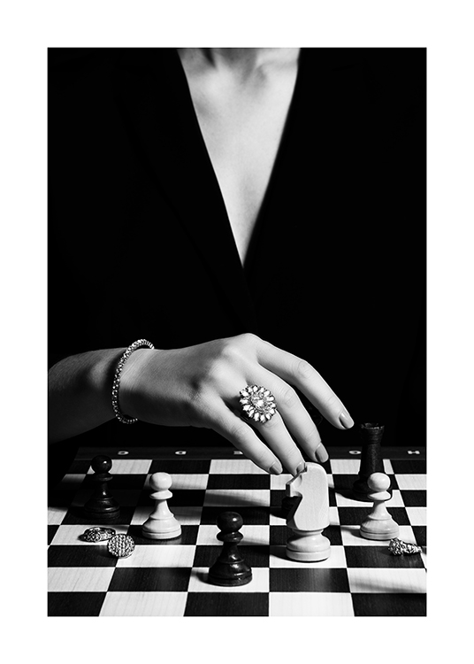 – Schwarz-weiß-Fotografie einer Schachspielerin mit einem großen Ring am Finger